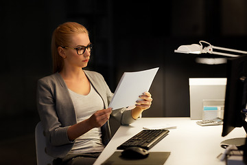 Image showing businesswoman with papers working at night office