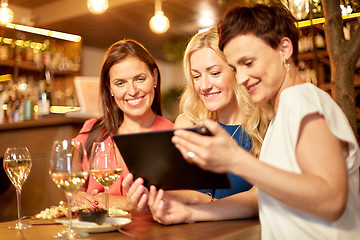 Image showing women with tablet pc at wine bar or restaurant