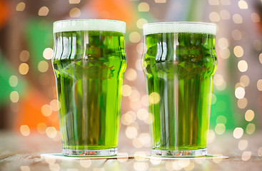 Image showing two glasses of green beer on wooden table