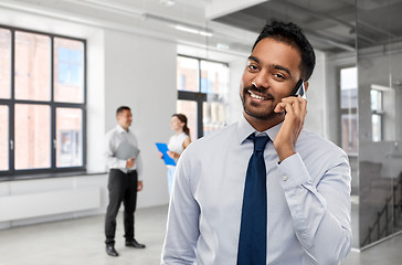 Image showing indian businessman calling on smartphone at office