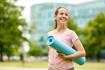 Image showing happy smiling woman with exercise mat at city park
