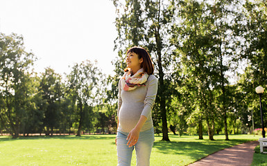 Image showing happy pregnant asian woman walking at park