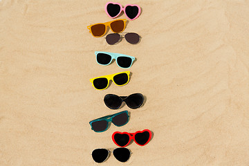 Image showing different sunglasses on beach sand