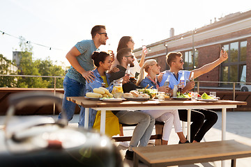 Image showing happy friends taking selfie at rooftop party