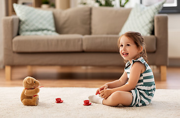 Image showing little girl playing with toy tea set at home