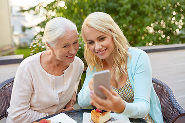 Image showing daughter and senior mother with smartphone at cafe
