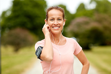 Image showing woman with earphones listening to music at park
