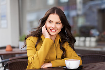 Image showing teenage girl drinking hot chocolate at city cafe