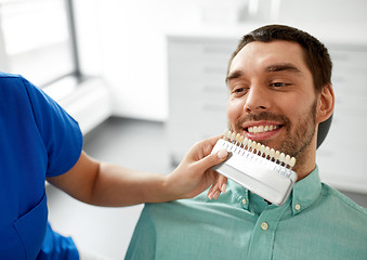 Image showing dentist choosing tooth color for patient at clinic