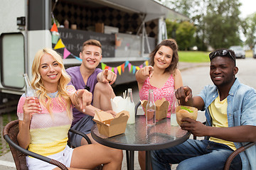 Image showing happy friends with drinks eating at food truck