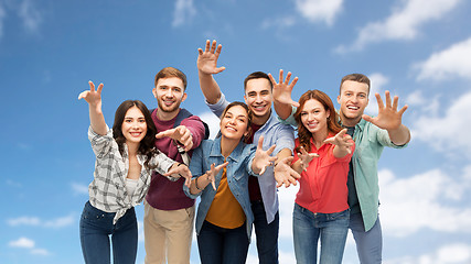 Image showing group of happy students over blue sky background