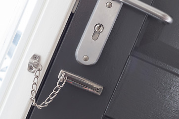 Image showing Door chain on a grey door