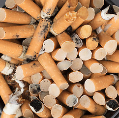 Image showing Overflowing ashtray, chain smoking