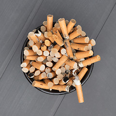 Image showing Overflowing ashtray, chain smoking