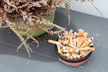 Image showing Overflowing ashtray, chain smoking