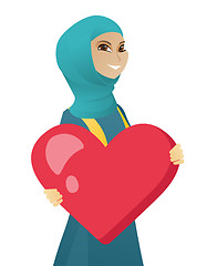Image showing Young muslim business woman holding a big heart.