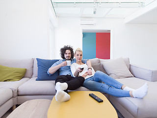 Image showing Young couple on the sofa watching television