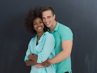 Image showing multiethnic couple in front of gray chalkboard