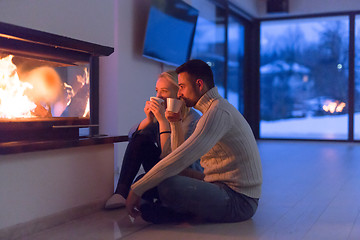 Image showing happy couple in front of fireplace