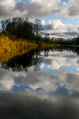 Image showing Autumn landscape with colorful trees, yellow grass and river. Re