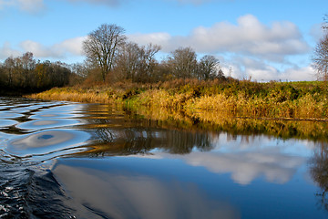 Image showing Autumn landscape with colorful trees, yellow grass and river. Re