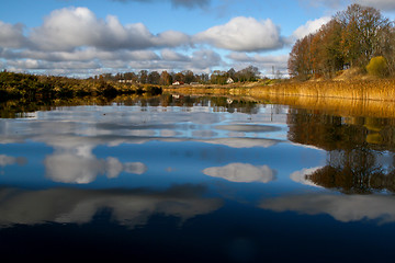 Image showing Autumn landscape with colorful trees, yellow grass and river. Re