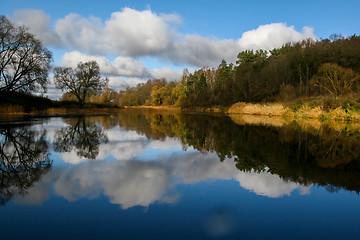 Image showing Autumn landscape with colorful trees, yellow grass and river. Re