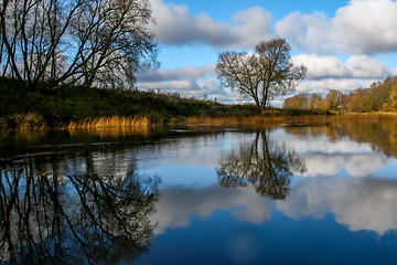 Image showing Autumn landscape with colorful trees, yellow grass and river. Re