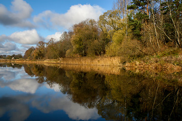 Image showing Autumn landscape with colorful trees, yellow grass and river. Re