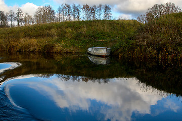 Image showing Autumn landscape with trees grass and boat in river. 