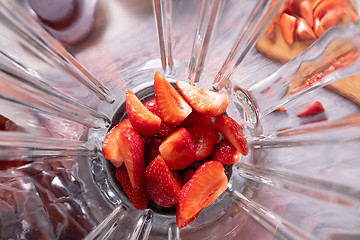 Image showing Pieces of ripe strawberries in a blender bowl. Preparation of smoothies. Top view