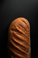 Image showing Freshly baked healthy white bread on a black background with copy space. Top view