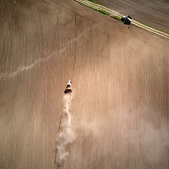 Image showing Aerial view tractor with a cultivator for seeds at the beginning of the spring season of agricultural work