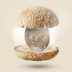 Image showing Burger with gold coin bitcoin on beige background