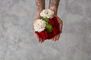 Image showing girl with a tattoo on her hands holding a bouquet of flowers