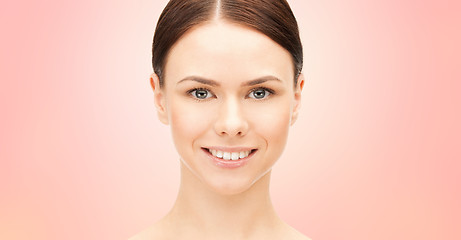 Image showing face of beautiful woman over pink background