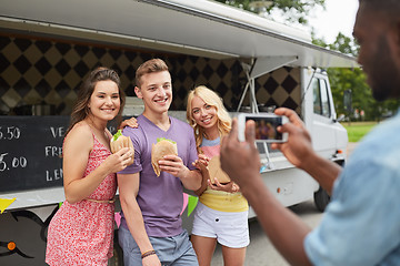 Image showing man taking picture of friends eating at food truck