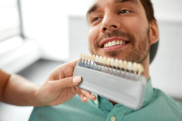 Image showing dentist choosing tooth color for patient at clinic