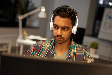 Image showing creative man with headphones working at office