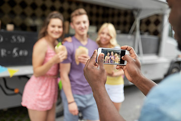 Image showing man taking picture of friends eating at food truck