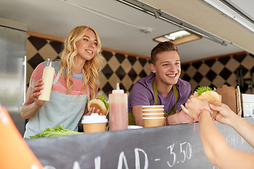 Image showing happy sellers serving customers at food truck