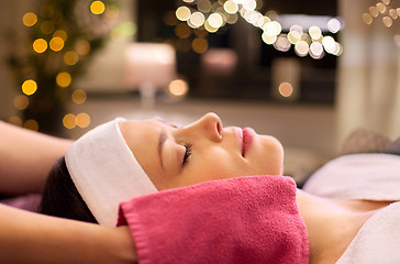 Image showing woman having face massage with terry gloves at spa