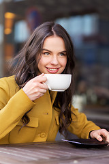 Image showing teenage girl drinking hot chocolate at city cafe