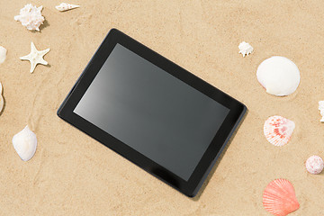 Image showing tablet computer and seashells on beach sand