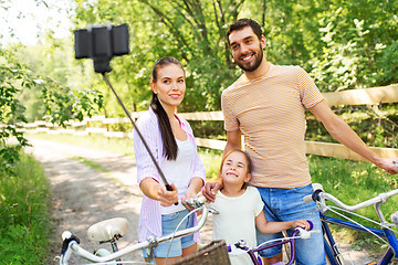 Image showing happy family with bicycles taking selfie in summer