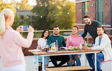 Image showing happy friends photographing at rooftop party