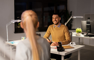 Image showing designer with laptop talking to coworker at office