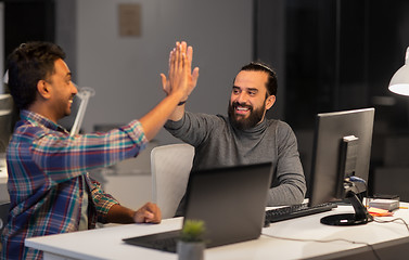 Image showing creative team making high five at night office