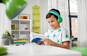 Image showing boy in headphones with textbook learning at home