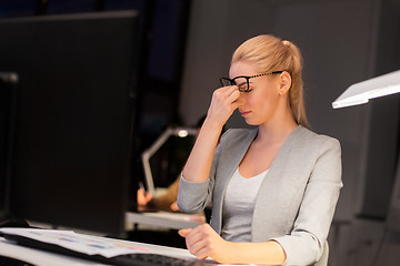 Image showing businesswoman rubbing tired eyes at night office